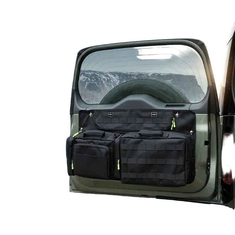 DEFENDER TACTICAL STORAGE tailgate organizer system on a vehicle with a mountainous landscape in the background.